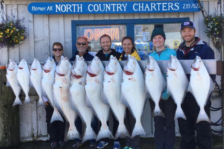 a group of people posing for a photo in front of a fish